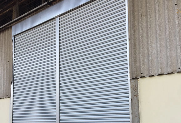 A closed Zincalume roller shutter covering the entrance to a warehouse