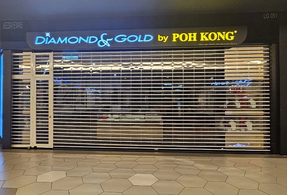 The storefront of Poh Kong's Diamond & Gold jewelry store, features closed roller shutters.