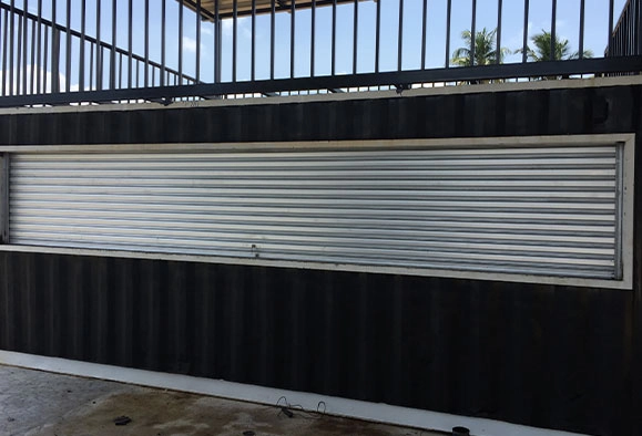 A Zincalume roller shutter covering a storefront window