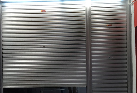 A closed Zincalume roller shutter covering a storefront